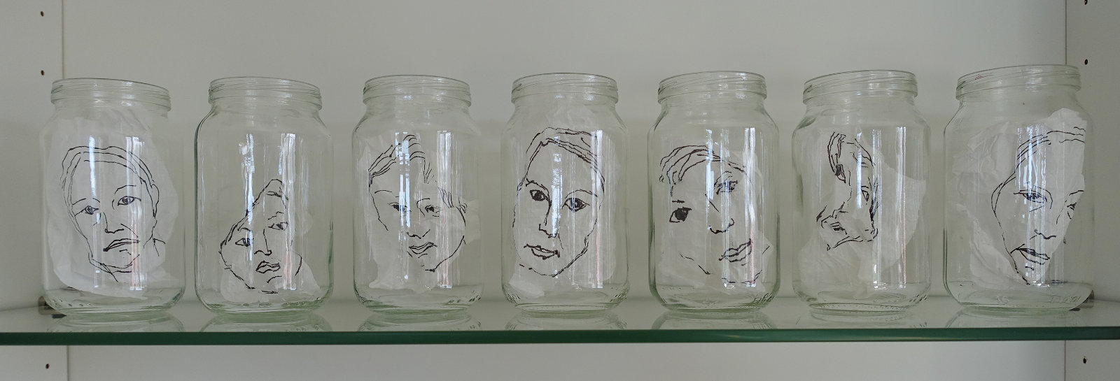 Väsymyksen kasvot, 2016, rypistellyt piirustukset lasipurkeissa, 12 x 48 x 6 cm 
